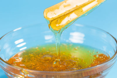 Close-up of yellow pouring drink in glass container