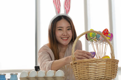 Portrait of smiling young woman holding basket