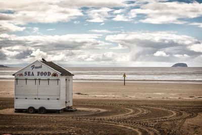 Lifeguard hut on beach against sky