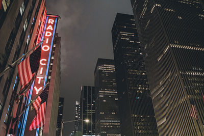 Low angle view of illuminated buildings against sky at night