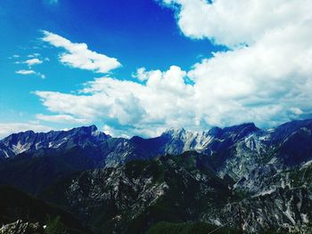Scenic view of snowcapped mountains against cloudy sky