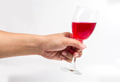 Midsection of woman holding drink against white background