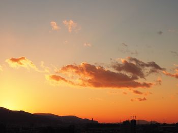 Silhouette city against sky during sunset