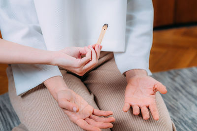 Peaceful woman sitting and meditating, spiritual coach with palo santo stick