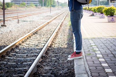 Low section of person standing on railroad track