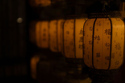 Close-up of five paper lanterns in a row with non-western script on it