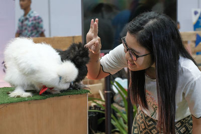 Smiling young woman looking at rabbit