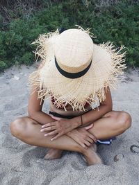 Midsection of woman sitting in hat