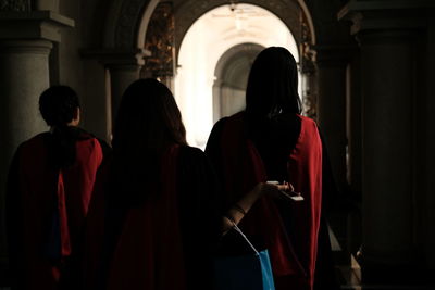 Rear view of people standing in corridor of building