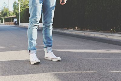 Low section of man standing on road