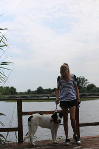 Women with bucovina shepherd dog standing next to lake