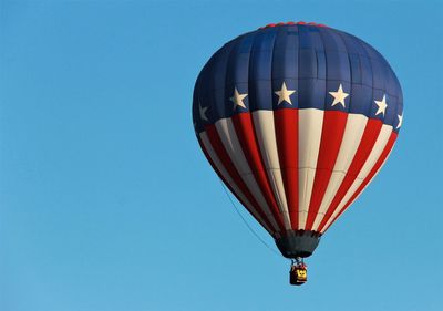 Low angle view of hot air balloon against clear blue sky