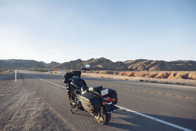 Motorcycle on road against mountain range