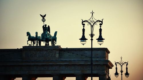 Low angle view of brandenburg gate and street lights against clear sky