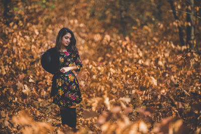 Young woman standing on rock during autumn