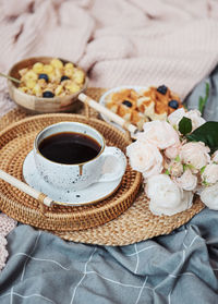 Coffee cup with roses bouquet, romantic breakfast with flowers