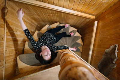 Portrait of woman lying on wooden spiral staircase