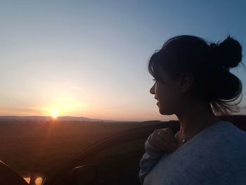 Portrait of young woman looking at sunset