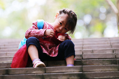 Full length of woman sitting on staircase