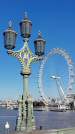 Ferris wheel in city against blue sky