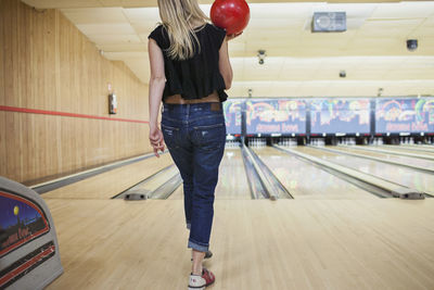 A young woman bowling.