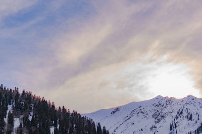 Low angle view of snowcapped mountains against sky