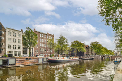 Boats in canal amidst buildings in city