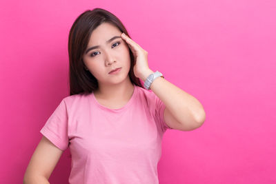 Portrait of a beautiful young woman over pink background