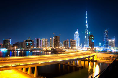 Bridge over river in city against clear sky