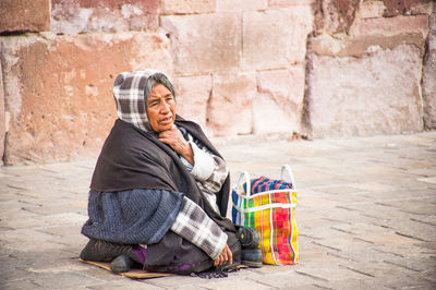 Man sitting on footpath