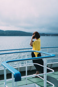 Rear view of woman looking at sea against sky