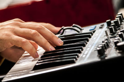 Close-up of hand playing piano