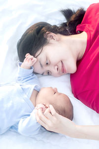 High angle view of cute baby girl lying on bed at home