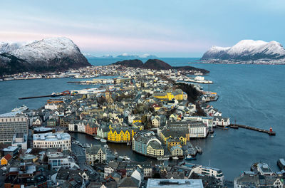 High angle view of city by sea against sky