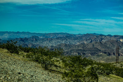 Scenic view of mountains against blue sky