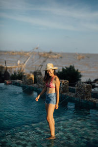 Full length of woman standing in water against sky