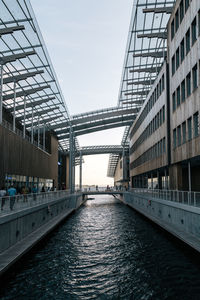 Bridge over canal in city against sky