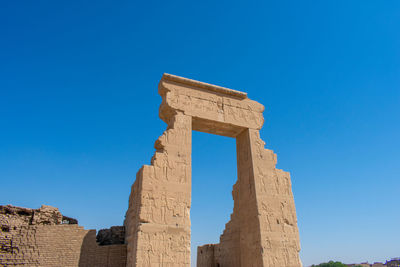 Low angle view of old ruins against clear blue sky