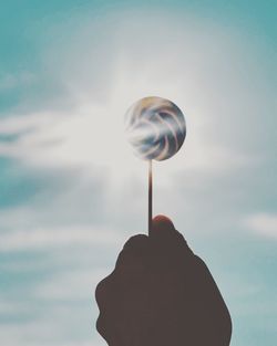 Person holding umbrella against sky