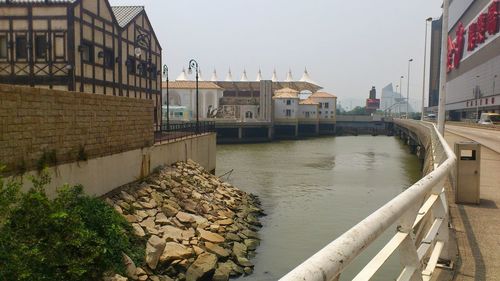 Canal amidst buildings against clear sky in city