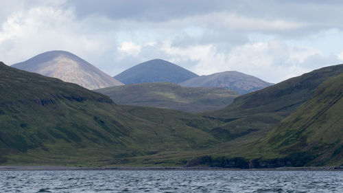 Scenic view of river and mountains against sky