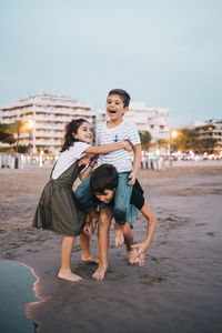 Full length of mother and daughter on beach against sky