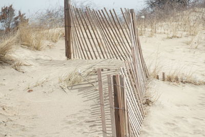 Wooden posts on beach against sky