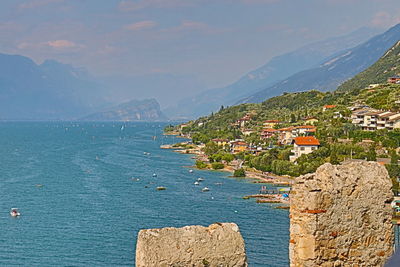 Scenic view of sea by town against sky