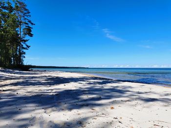 Scenic view of beach against blue sky