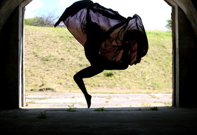 Full length of woman dancing against hill