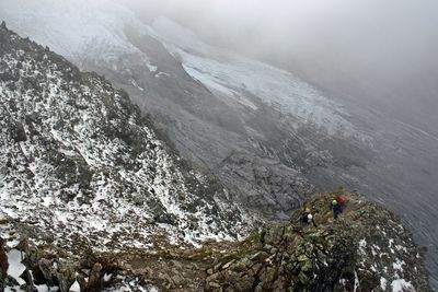 Scenic view hikers on snow covered mountain range