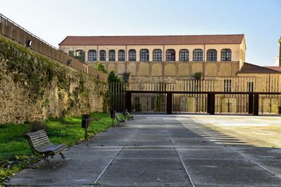 Empty benches on footpath against buildings. inside castle.