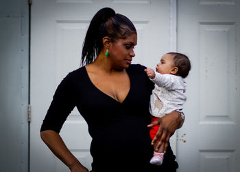 Mother and daughter standing at home