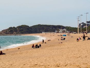 People at beach against sky